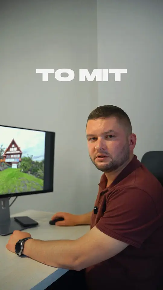 Artur Zając w bordowej koszulce polo przy biurku, nad nim napis „TO MIT”, na monitorze zdjęcie domu
